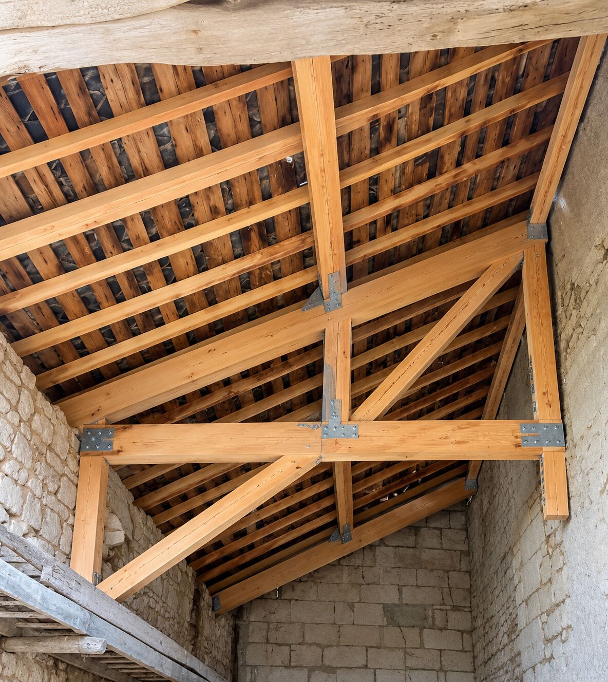 Charpente traditionnelle en bois rénovée, poutres et pannes apparentes
